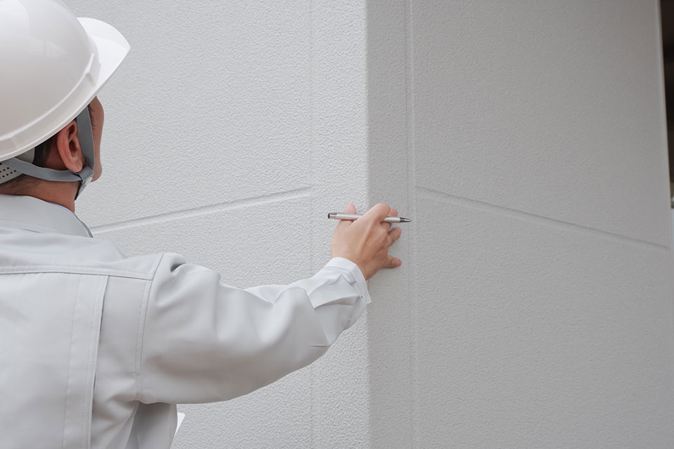 外壁の状態を確認している作業員