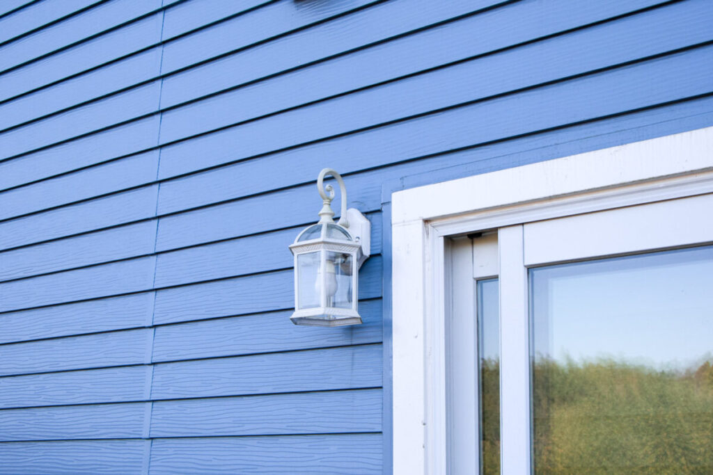 青く塗装された外壁と白い洋風のランプが写っている
