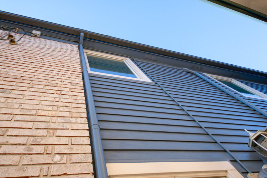 レンガと青のバイカラーの外壁を写した写真