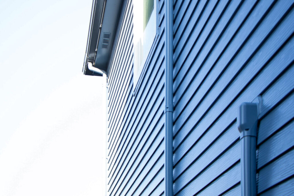 外壁と同じ青色で塗装された雨樋