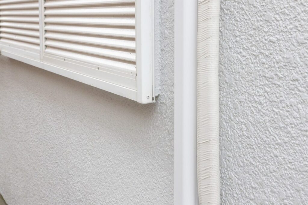 白い外壁のクローズアップ写真。白く塗装された雨樋と雨戸も写っている
